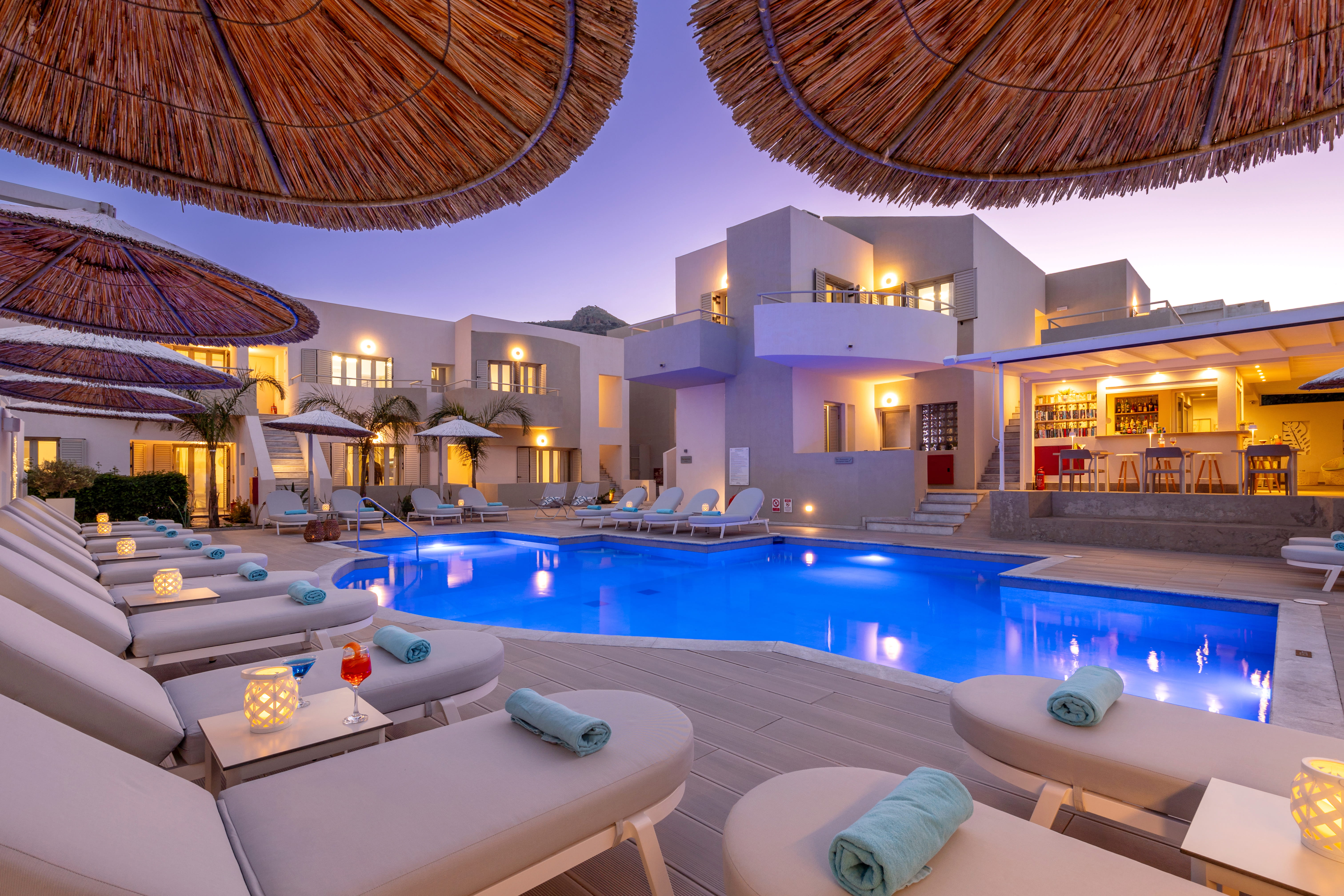 Relaxing boutique hotel pool surrounded by palms and white buildings